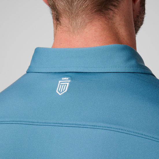 Blue polo shirt with collared neckline and small logo on back shoulder.