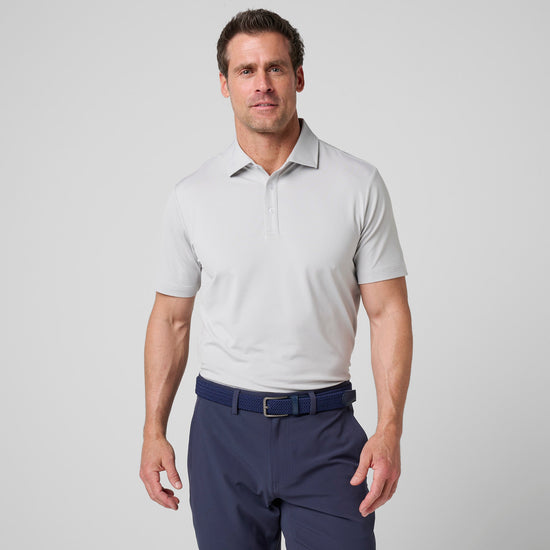 Man wearing light gray short-sleeve polo shirt with collar and button placket, paired with dark navy pants and blue belt.