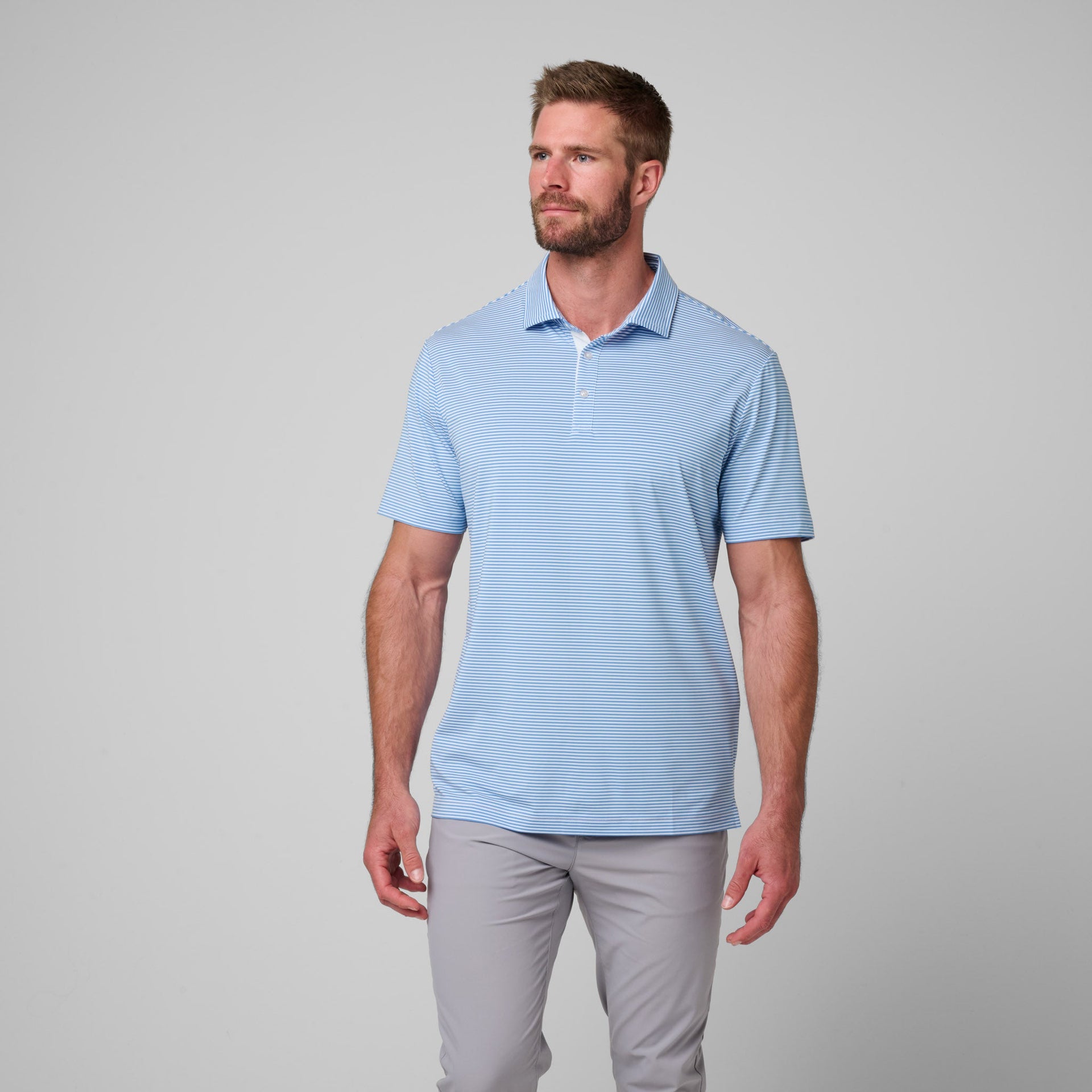 Man wearing light blue striped polo shirt with white collar and gray pants.