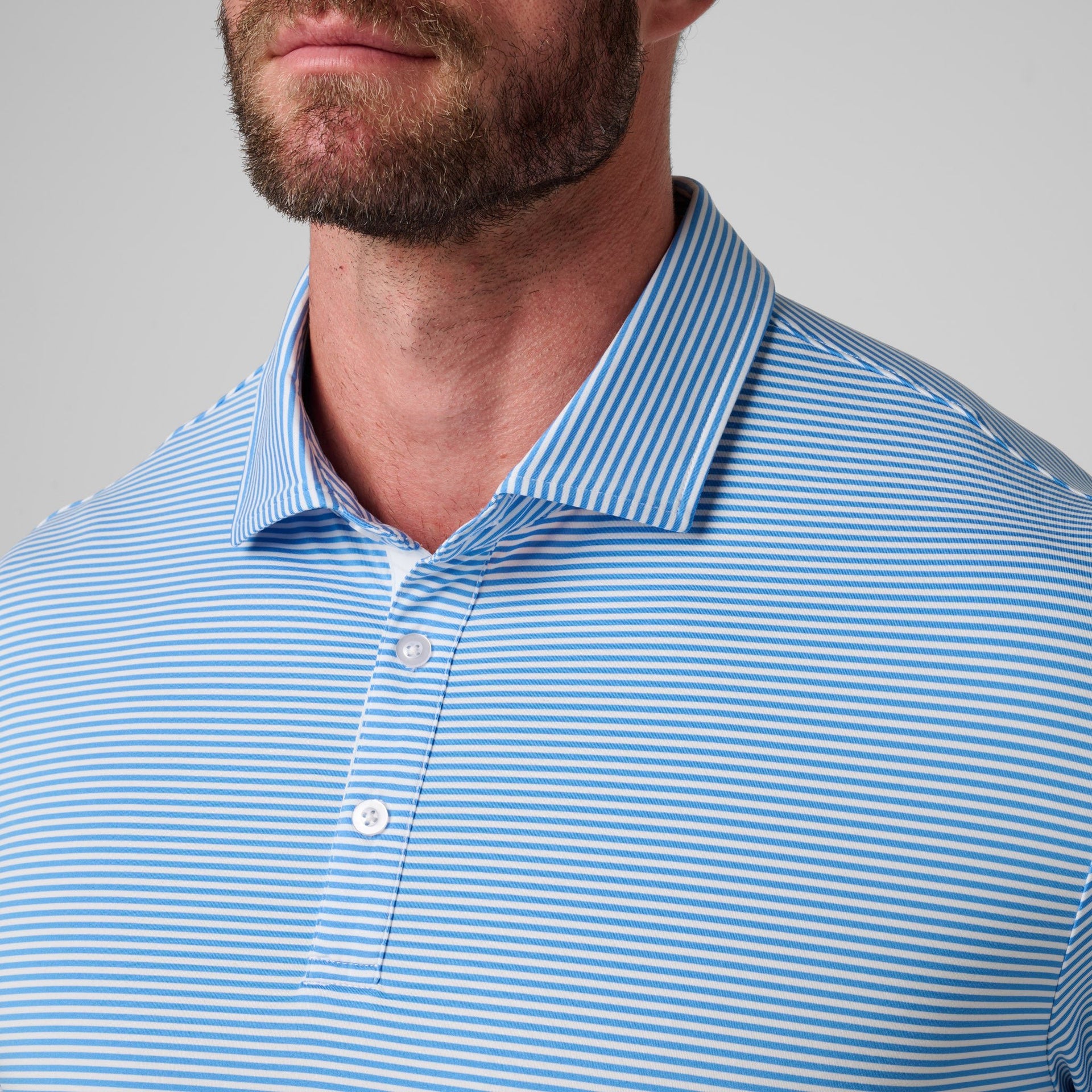 Man wearing blue and white striped polo shirt with collared neckline and button front.