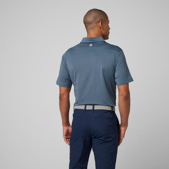 Man wearing blue striped polo shirt with collar and navy pants viewed from back.