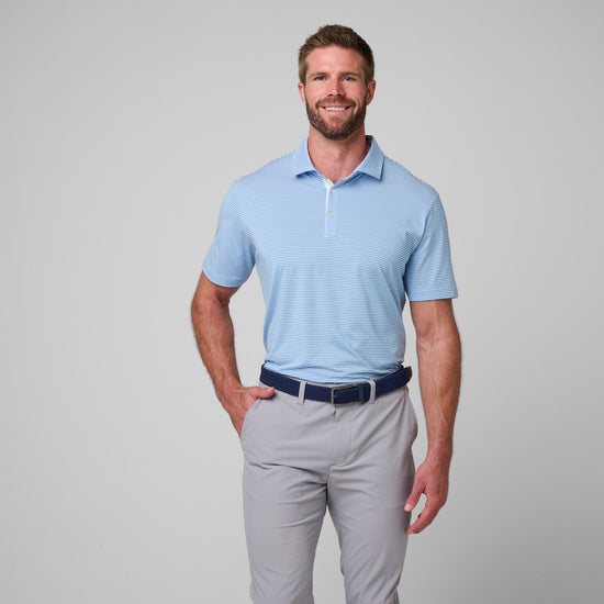Man wearing light blue striped polo shirt with white pinstripes and gray pants with navy belt.