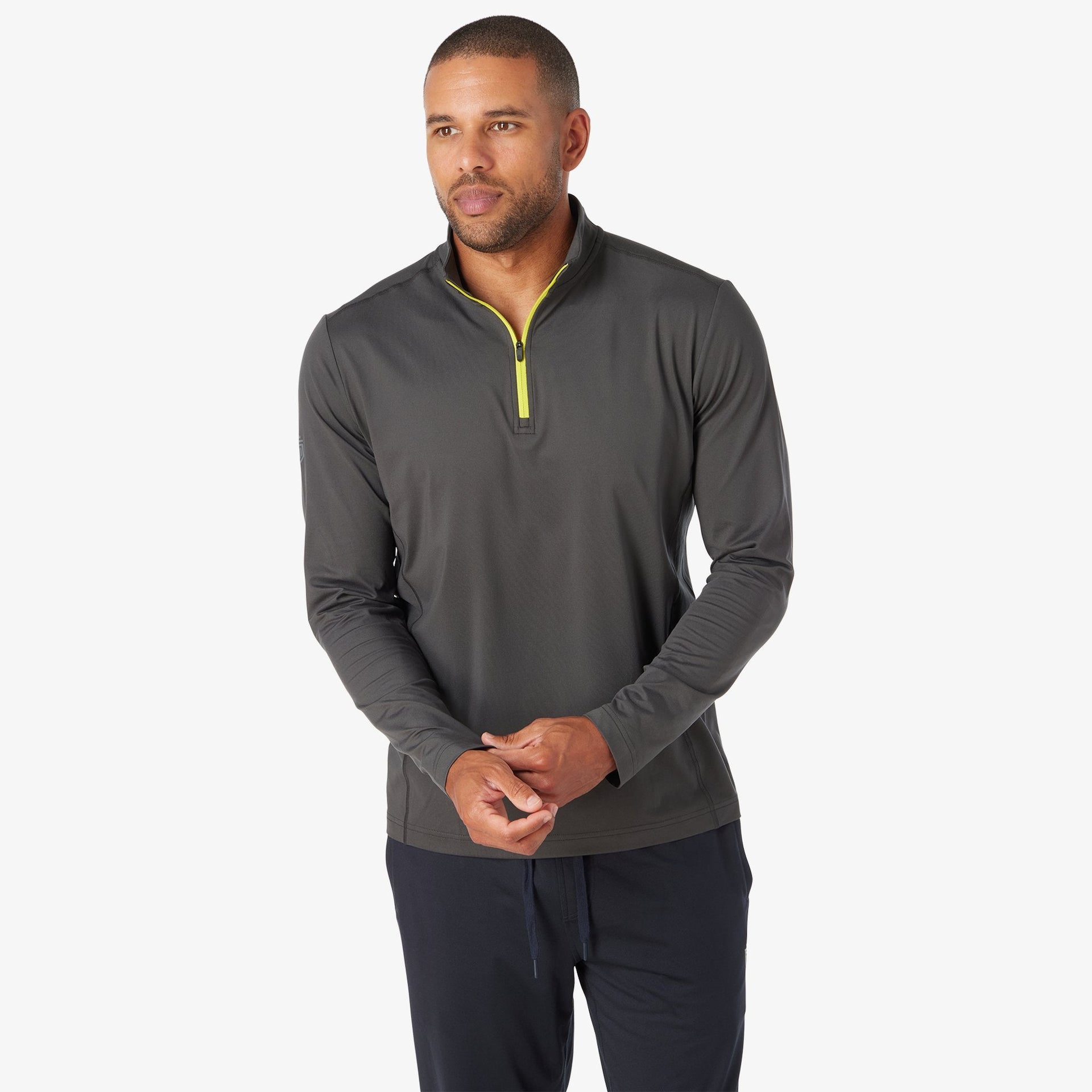 Man wearing charcoal quarter-zip pullover with yellow zipper and dark navy pants.