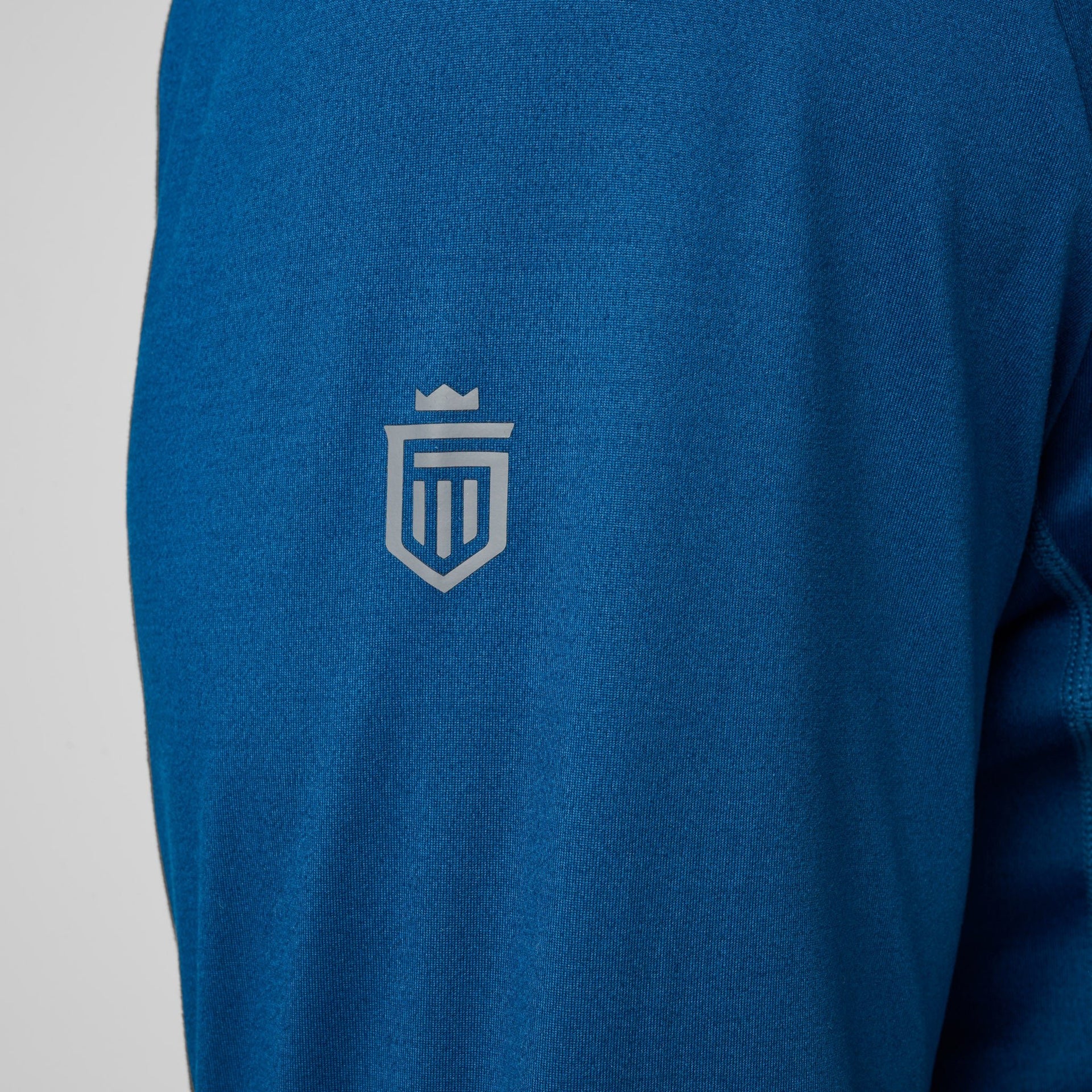 Blue quarter zip pullover with gray crest logo on chest.