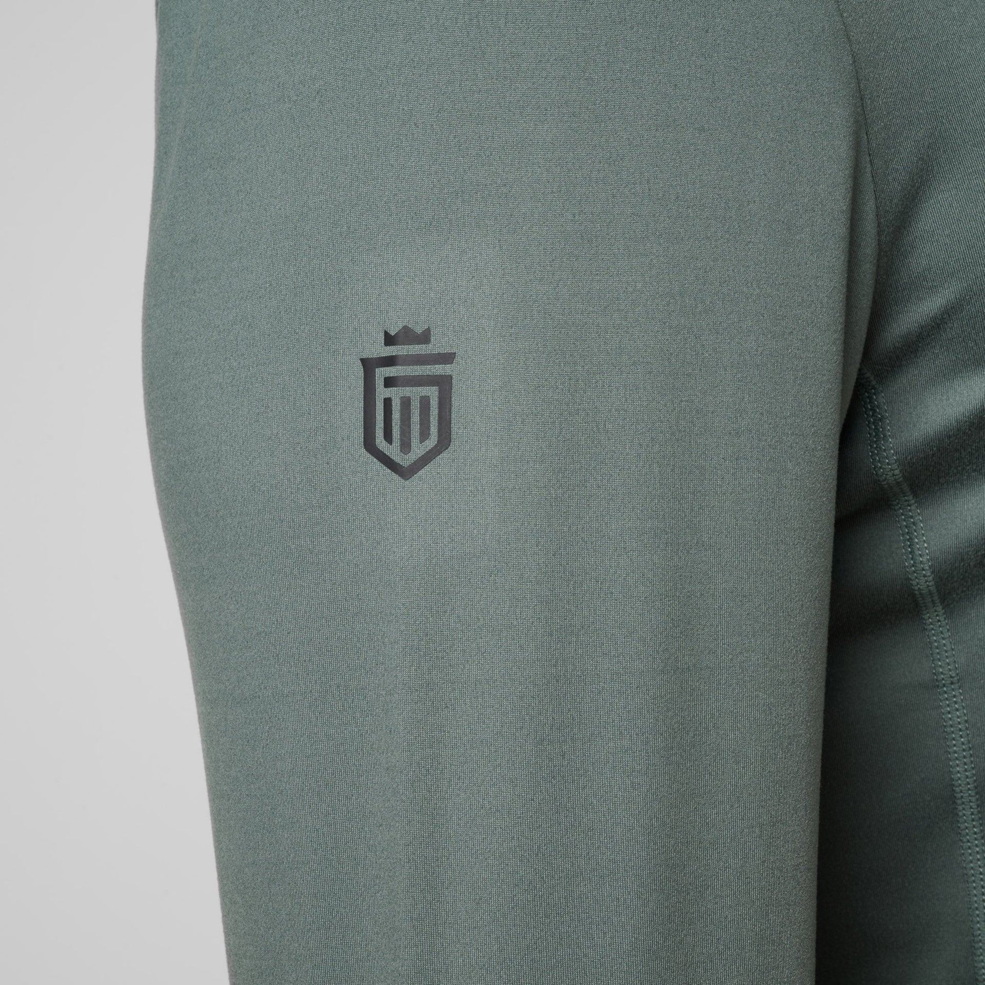 Sage green quarter zip pullover with embroidered shield logo on chest.