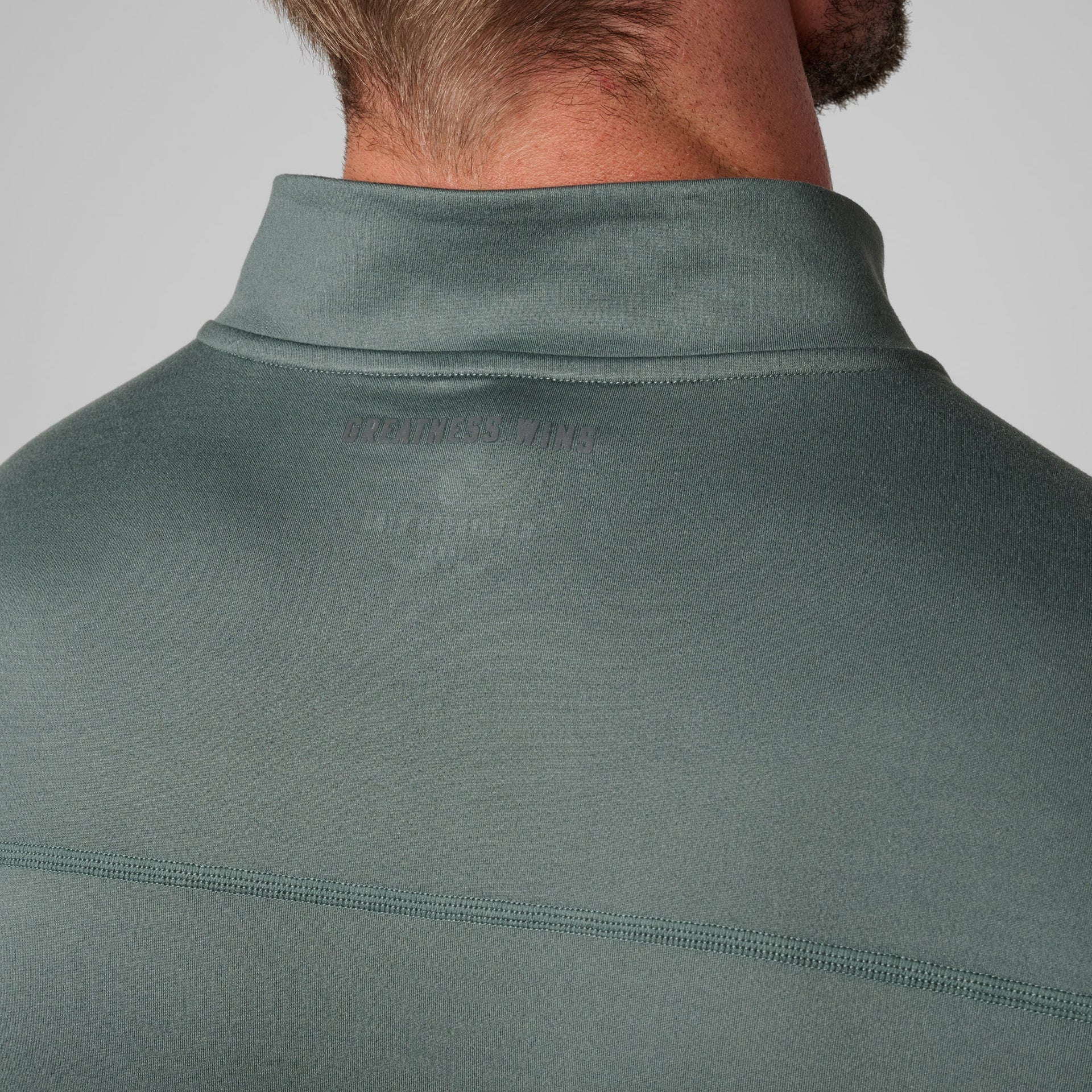 Sage green quarter-zip pullover with mock neck collar shown from behind on a man.