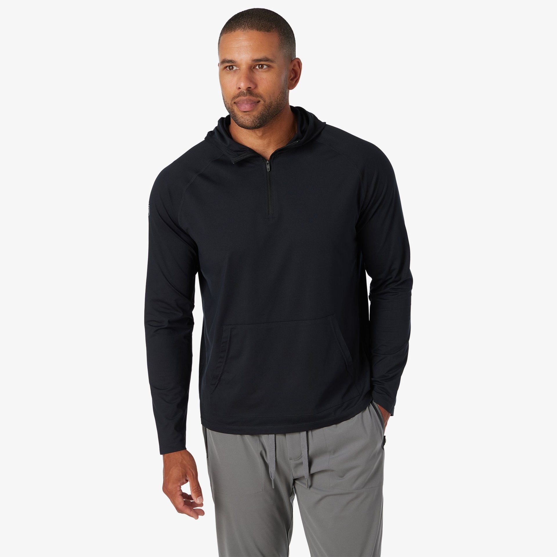 Black quarter-zip hoodie with long sleeves and front kangaroo pocket, paired with gray pants.