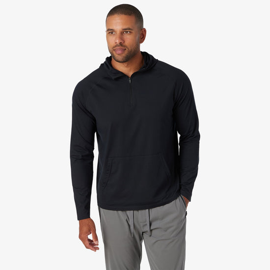 Black quarter-zip hoodie with long sleeves and front kangaroo pocket, paired with gray pants.