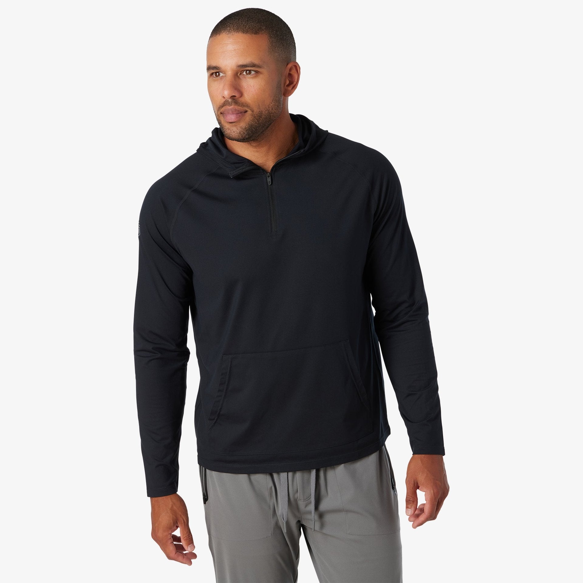 Black quarter zip hood with kangaroo pocket, worn with gray pants.