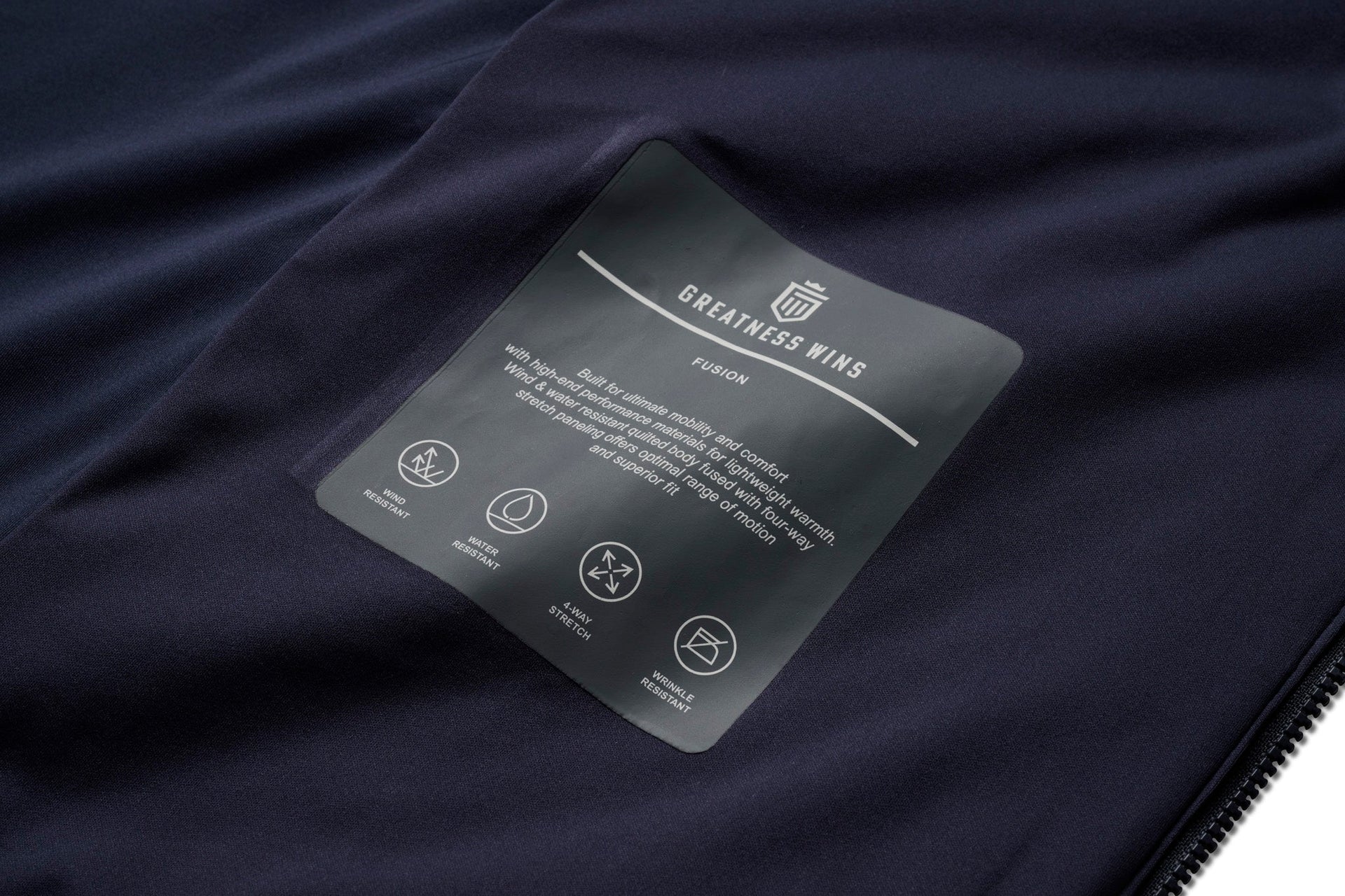 Dark navy hybrid jacket with care instruction label showing product features and washing icons.