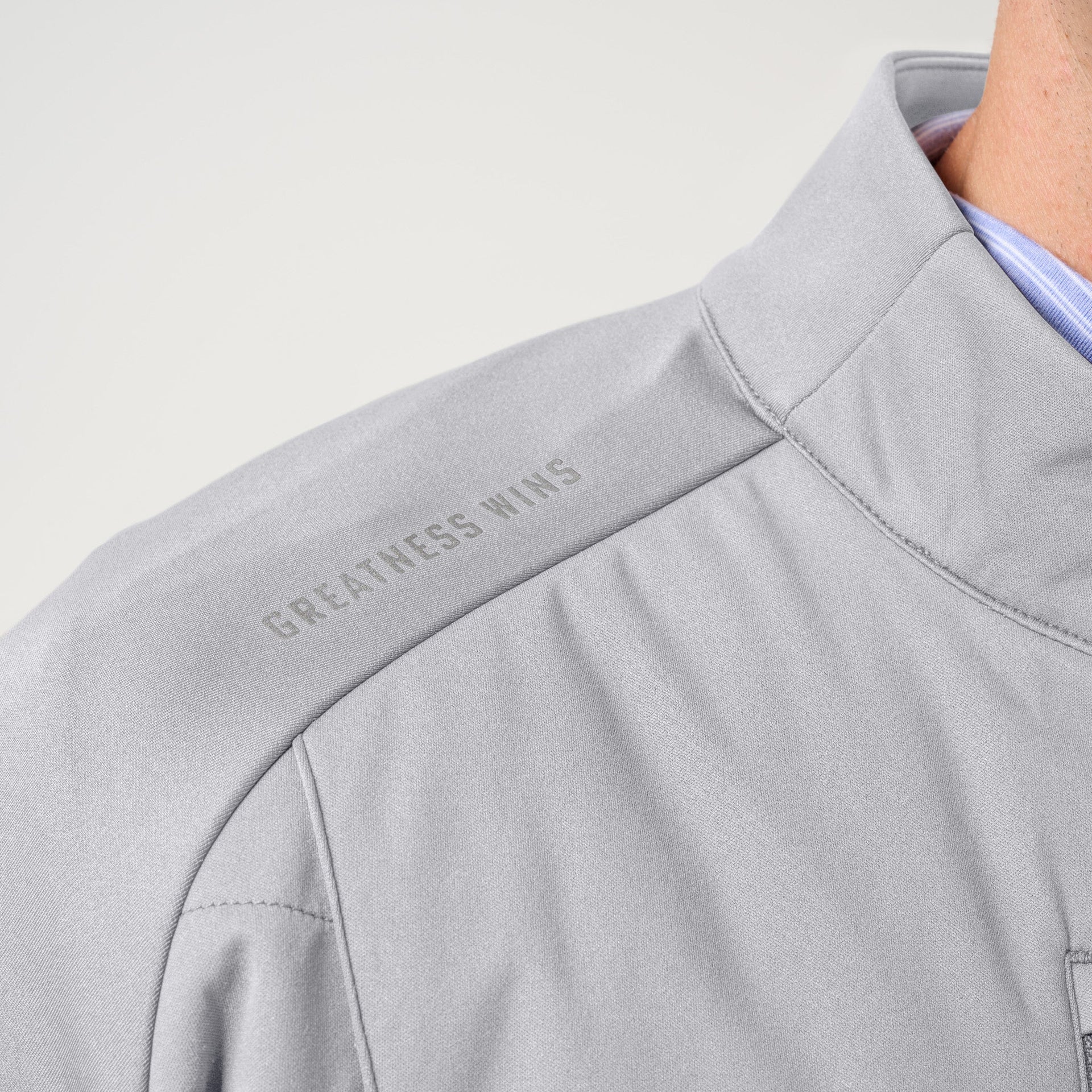 Light gray hybrid jacket with textured fabric and blue striped interior lining visible at collar.
