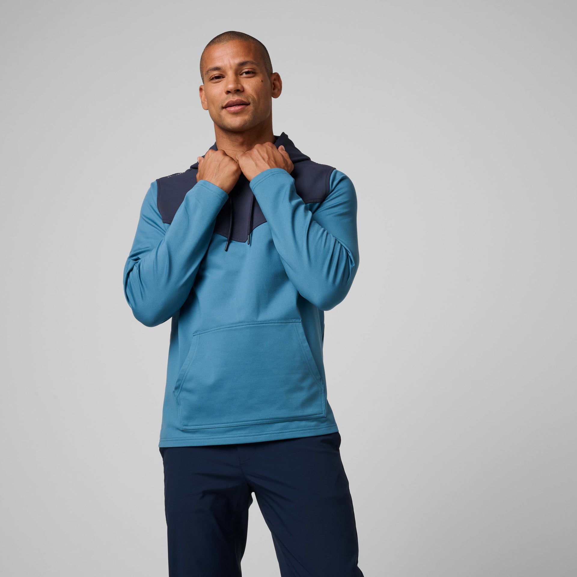 Helitech Performance Jackets Man wearing blue and navy colorblock hoodie with kangaroo pocket and ...