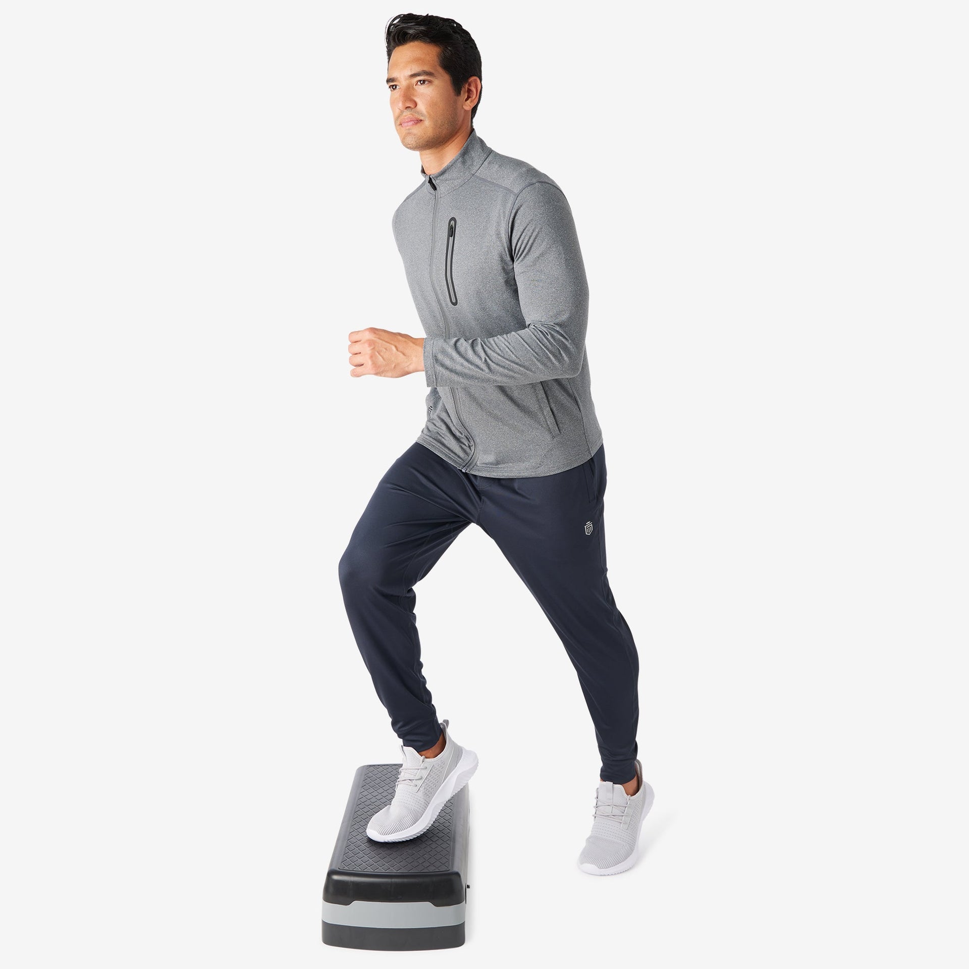 Man wearing gray full-zip athletic jacket with dark navy pants and ...