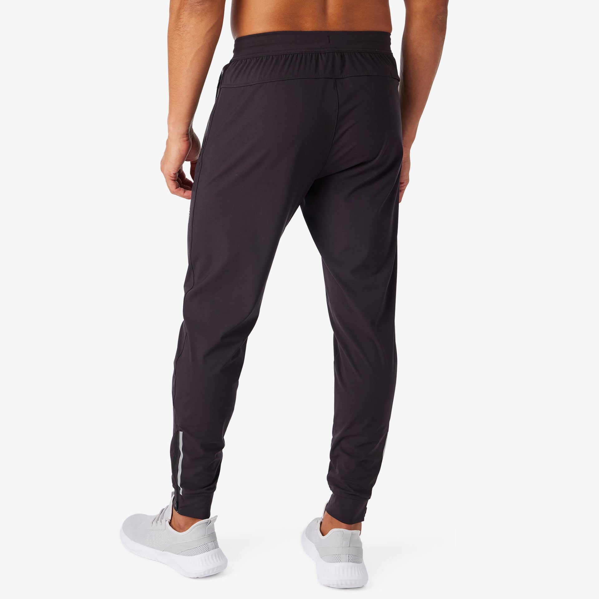 Performance Tech Black joggers with elastic waistband and tapered legs, worn with white ...